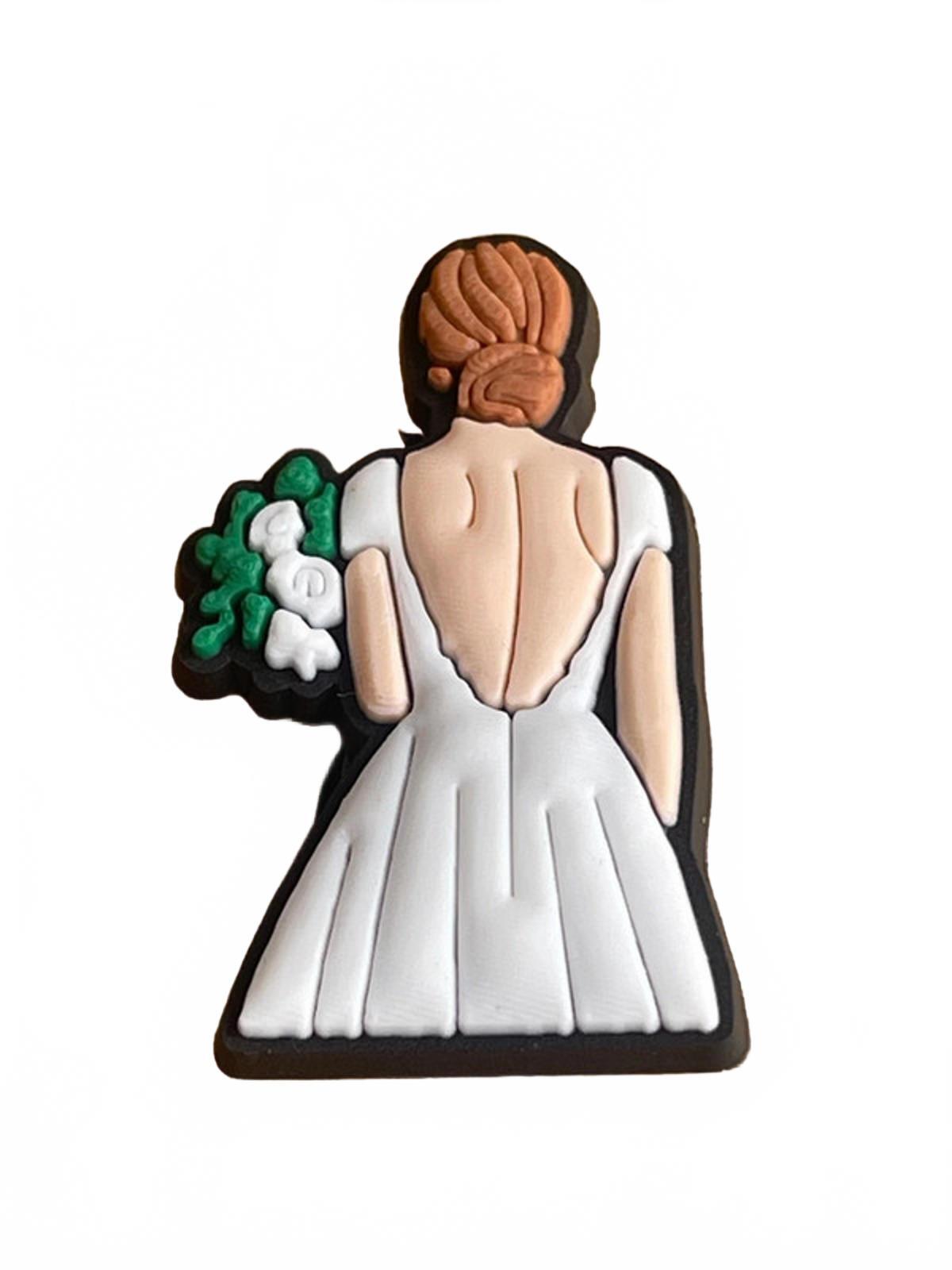 Bride in white gown holding flowers wedding shoe charm