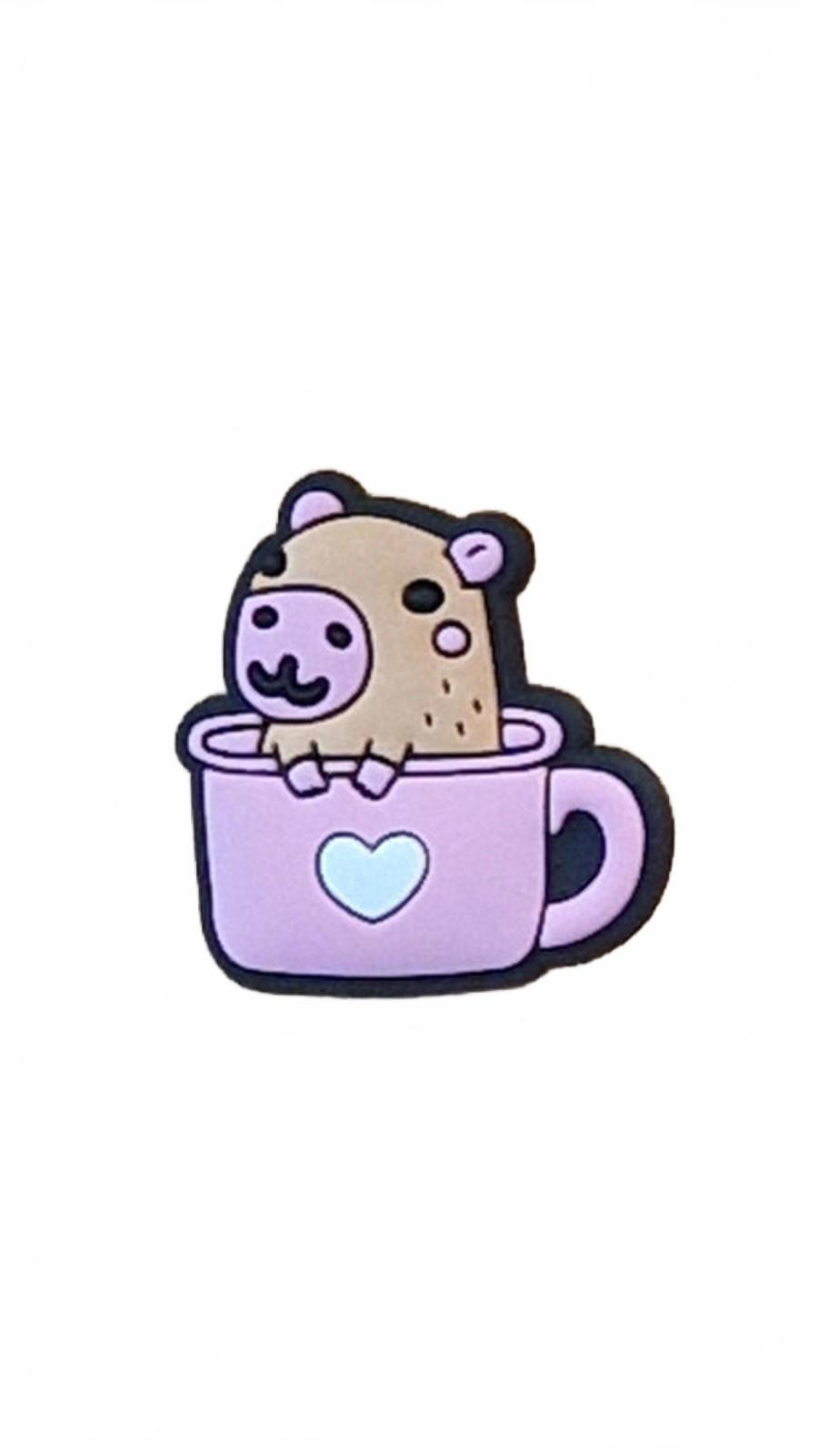 Cute brown capybara sitting in pink tea cup with heart shoe charm
