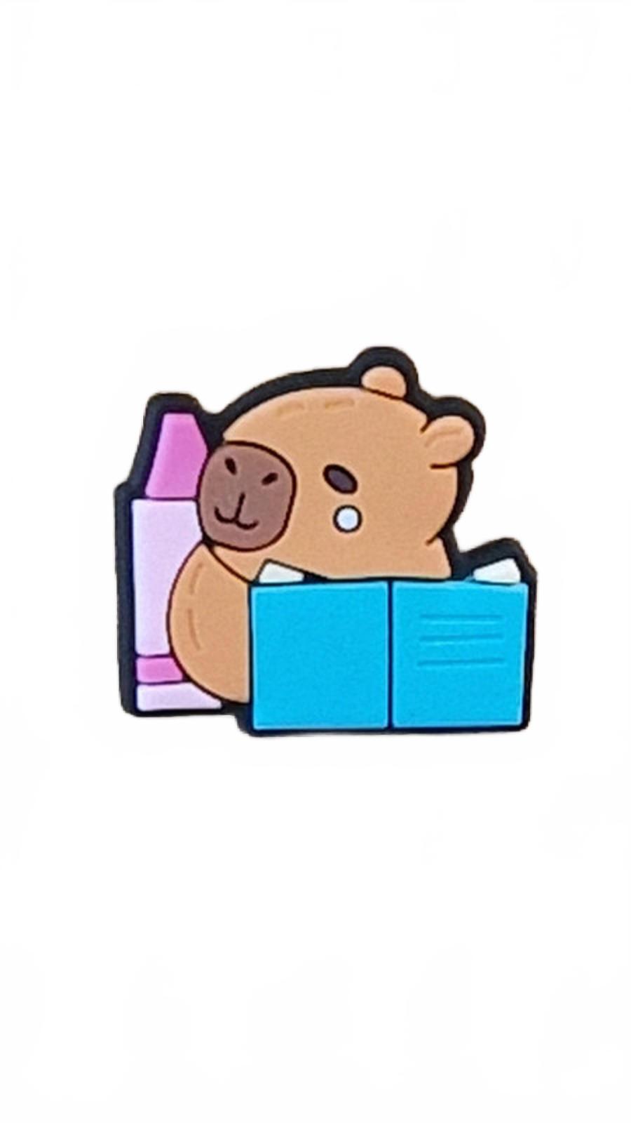 Cute capybara reading blue book with pink crayon shoe charm
