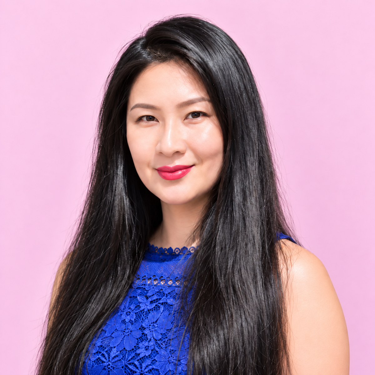 Lei Hang A woman with long, straight black hair wearing a blue lace top, posing against a solid pink background.