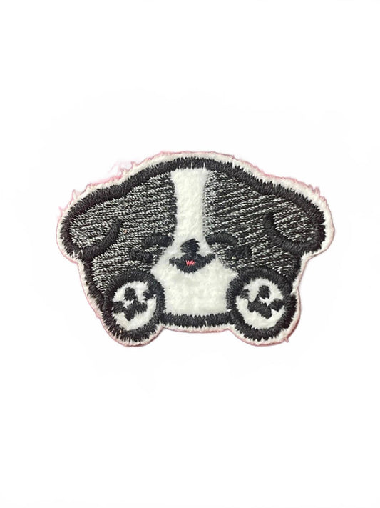 Cute embroidery patch of black and white dog with paws