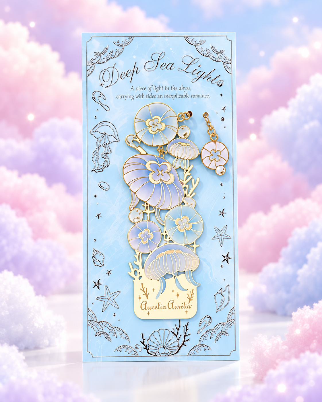 Blue packaged metal bookmark with gold-tone sea flowers and jellyfish details.