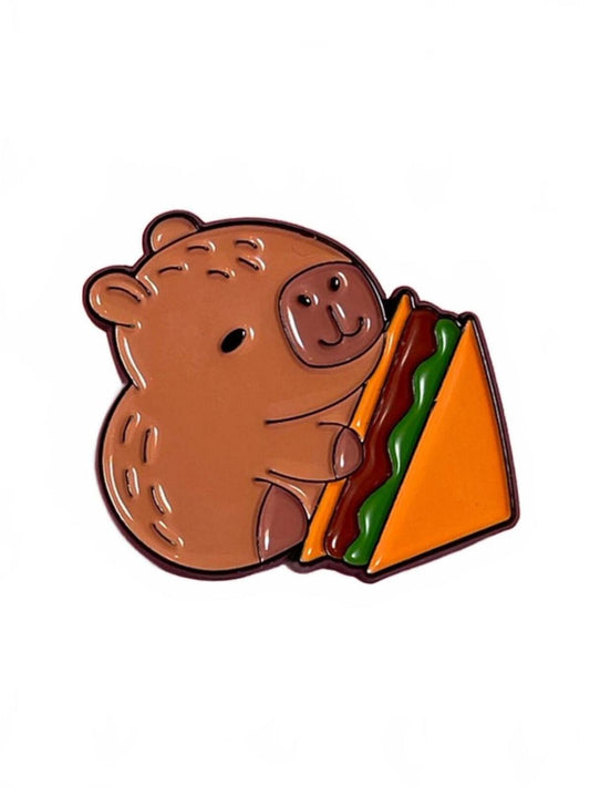 Enamel pin of a cute capybara holding a sandwich on a white background