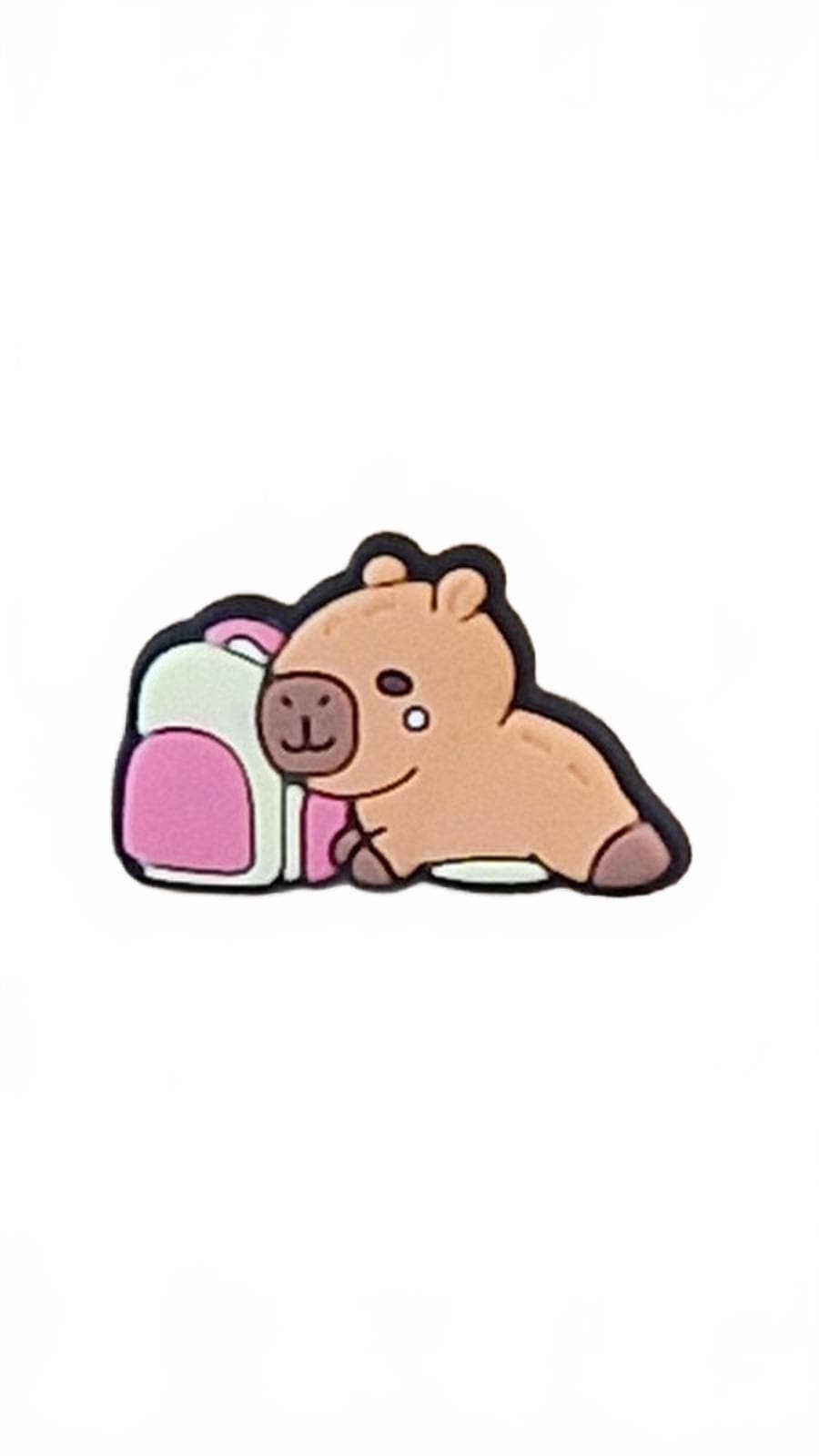 Cute capybara lying next to a white and pink backpack on a white background