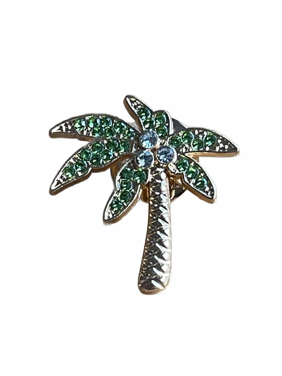 Palm tree brooch with green and clear gemstones on a white background