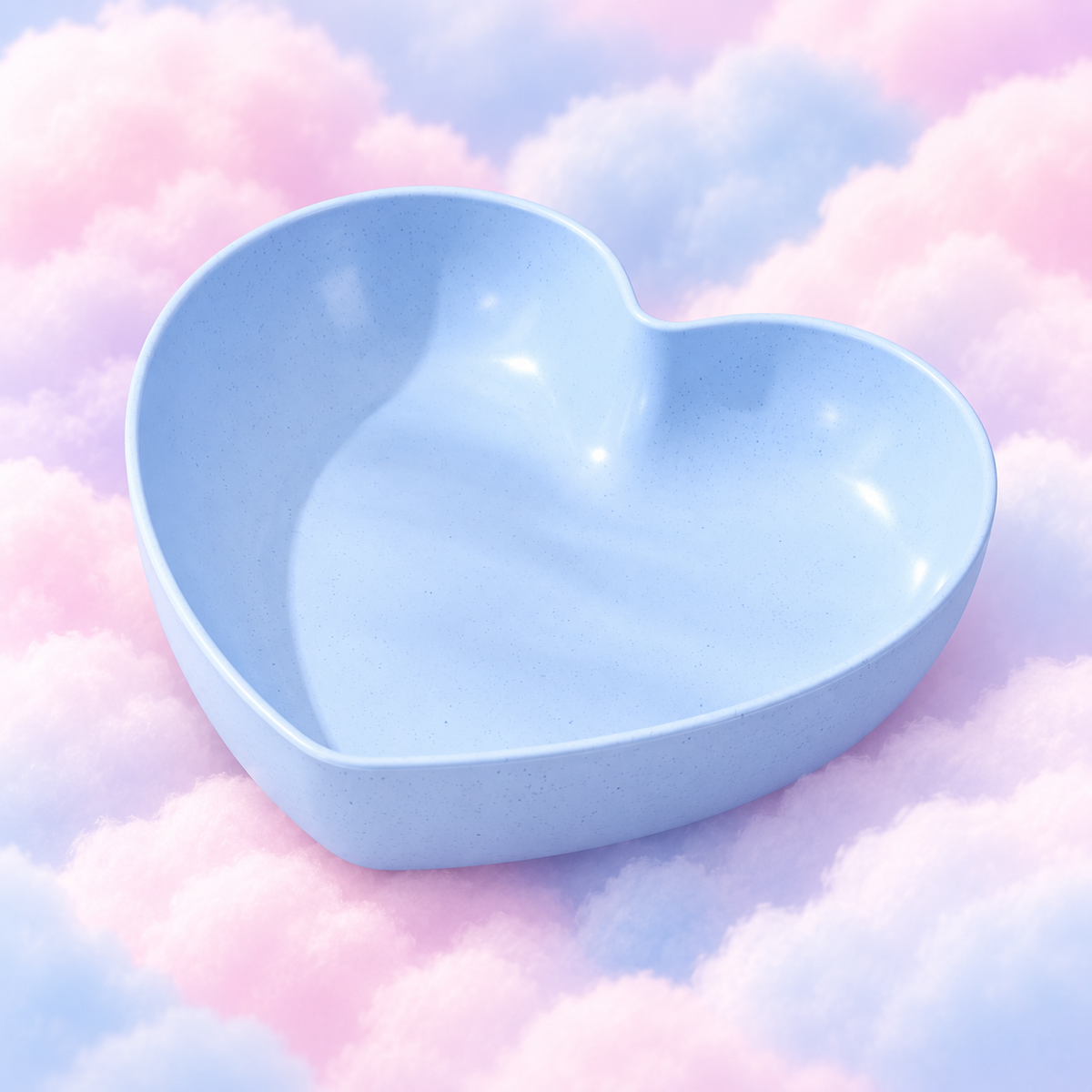 Blue heart-shaped plastic bowl with a speckled finish on pastel clouds.