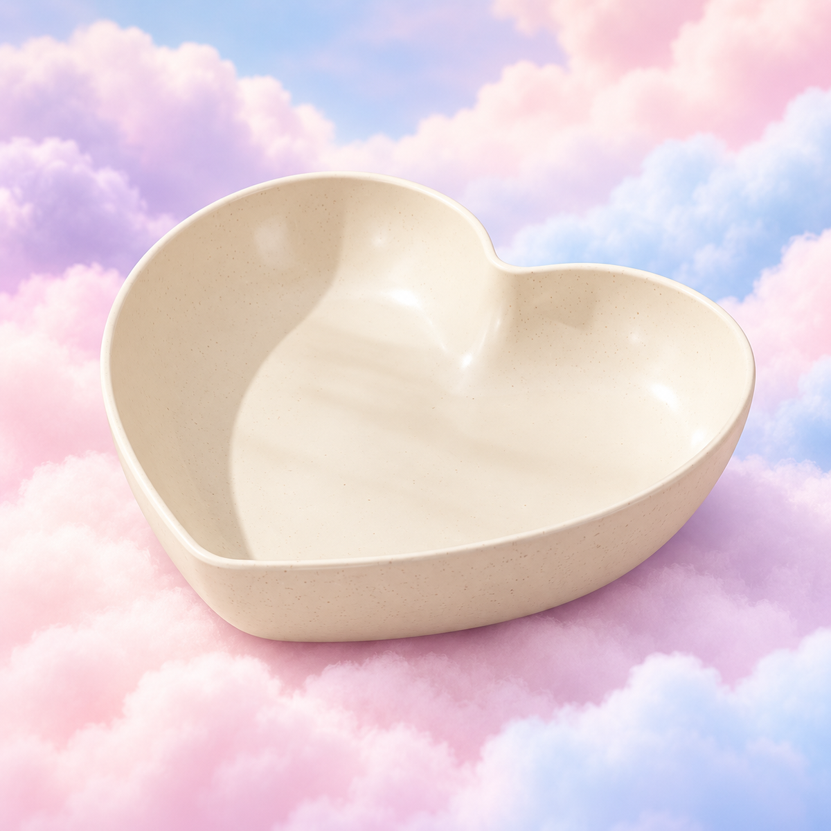 Cream heart-shaped plastic bowl with a speckled finish on pastel clouds.