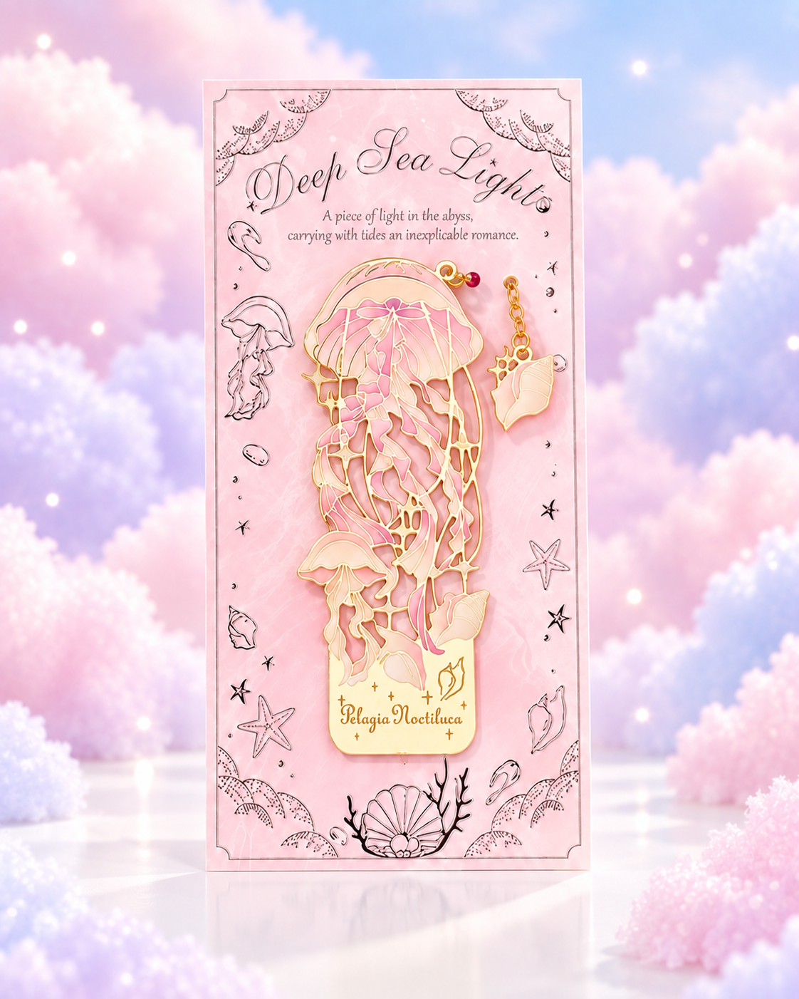 Pink packaged gold-tone metal bookmark with a delicate jellyfish design and shell charm.