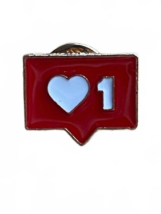 Red enamel pin with a white heart and number 1 social media design on a white background