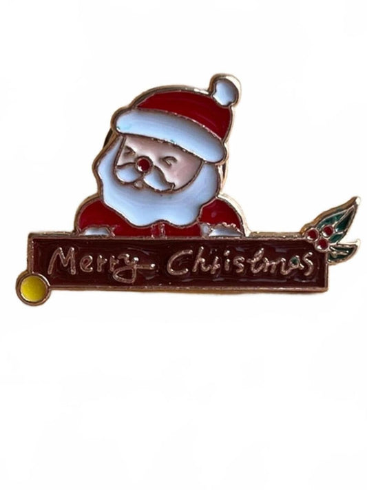 Christmas-themed enamel pin with Santa Claus holding a 'Merry Christmas' sign on a white background