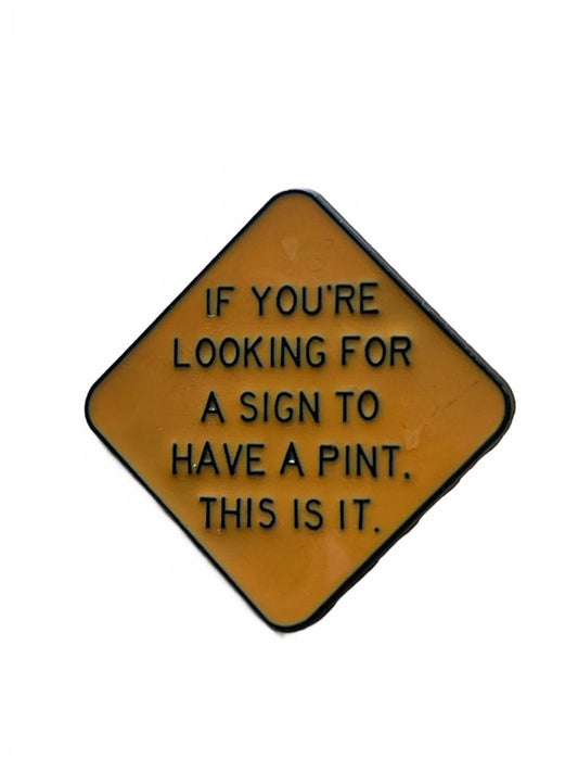 Yellow signage saying If you're looking for a sign to have a pint. This is it - enamel pin