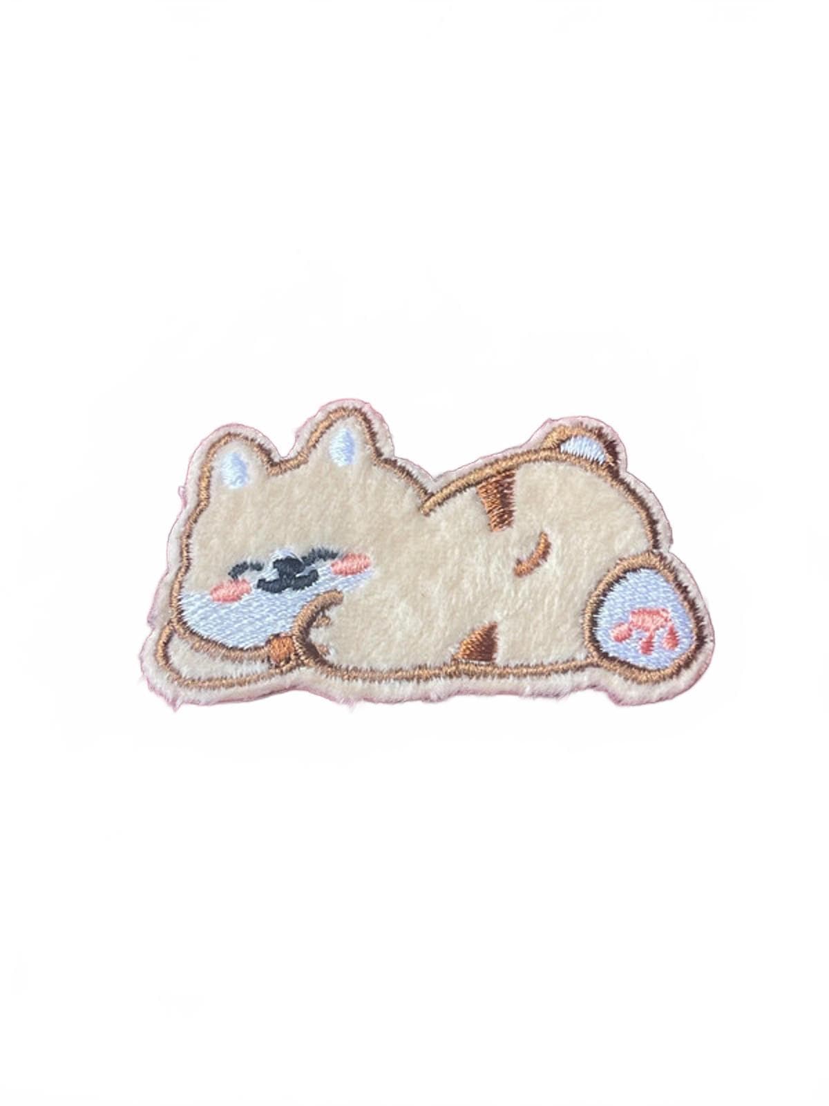 Embroidered patch of a cartoon dog sleeping on a white background