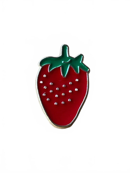 Strawberry shaped enamel pin with green leaves on a white background