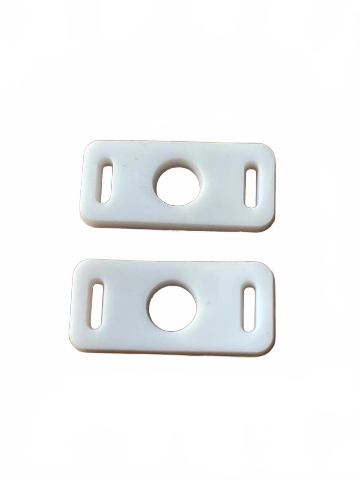 Two white shoe clip adaptors with holes on a white background